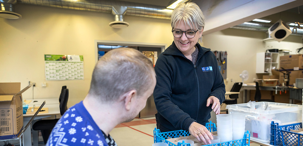 Borger og medarbejder pakker skruer i pakkeri på Kilen.