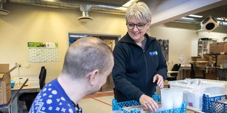 Borger og medarbejder pakker skruer i pakkeri på Kilen.