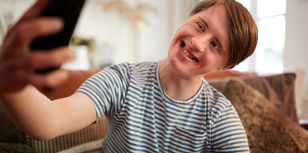 Ung mand med et udviklingshandicap tager et selfie.