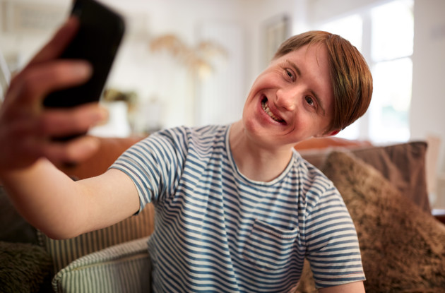 Ung mand med et udviklingshandicap tager et selfie.