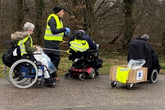 Affaldsindsamling med borger i gule refleksveste.